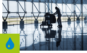 Reinigungskraft wischt einen Boden mit einer Bodenwischmaschine.